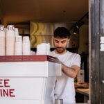A barista is making coffee behind a counter.